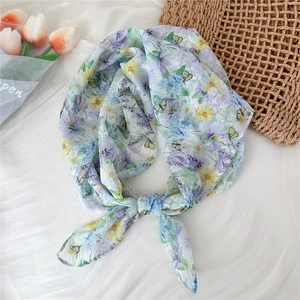 Detail of lightweight breathable square scarf with floral butterfly print tied in a bow