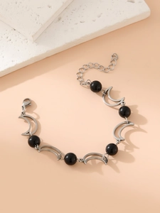 Detail of silver sun and moon chain bracelet with black beads and crescent moon links