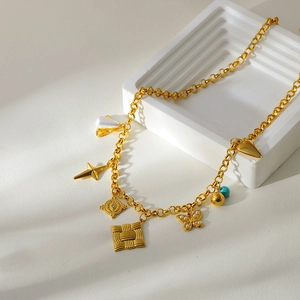 Detail of gold fringe necklace featuring star, pearl butterfly and turquoise pendants