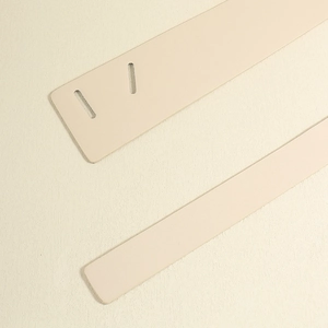 Close-up detail of beige PU leather knot belt showing fine texture and punched holes