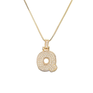 Detailed macro shot of a golden bubble letter Q pendant with cubic zirconia inlay