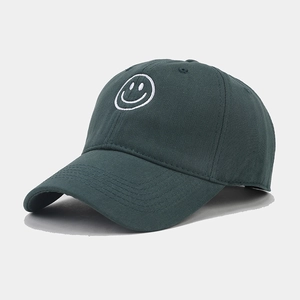 Close-up of a dark green baseball cap featuring a white embroidered smiley face logo