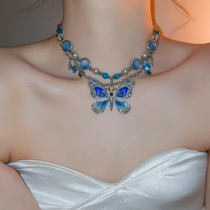 Détail du collier double rang avec pendentif papillon en cristal bleu et perles