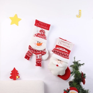 Large festive Christmas stockings with Santa and Snowman embroidery on white wall background