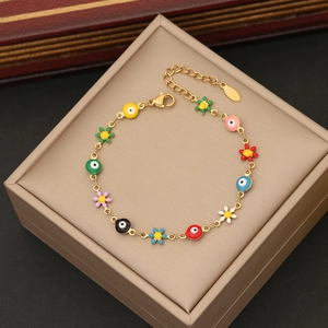 Detail of gold-plated stainless steel chain bracelet with colorful evil eye and daisy charms