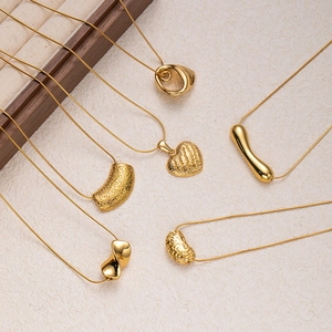 Minimalist gold titanium steel necklaces with heart and bar pendants on display