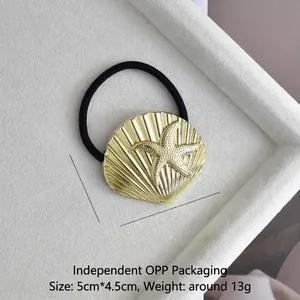 Detail view of golden starfish and shell hair tie in a white velvet display box