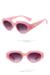 Detail view of jelly pink irregular sunglasses with thick frames and gold temple accents