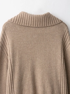 Detail of the high-density ribbed knit pattern on the beige cardigan shoulder and collar