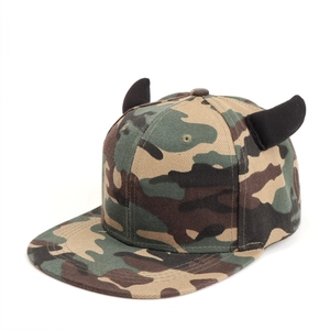 Close-up of camouflage flat brim hip-hop hat featuring black 3D devil horns on top