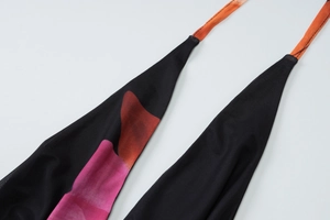 Detailaufnahme von schwarzem Netzstoff mit leuchtendem geometrischem Druckmuster