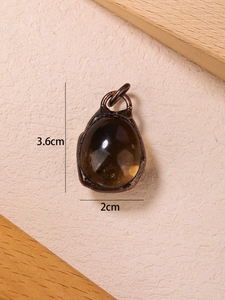 Detail shot of vintage bronze-wrapped brown stone pendant with dimensions 3.6cm by 2cm