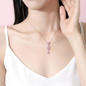 Elegant S925 silver necklace featuring three pink cherry blossom pendants on a model