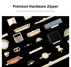 Close-up of golden metal hardware parts for purses including zipper pulls and charms