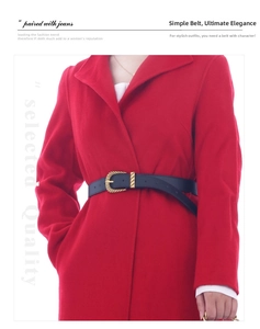 Detail of a thin black leather belt with golden metal buckle on a red wool coat