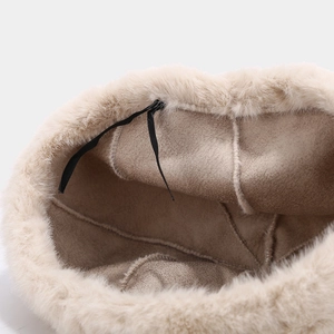 Interior view of warm beige plush beret showing soft faux suede texture and fluffy trim