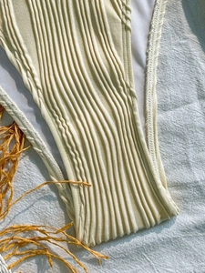 Detail view of the vertical ribbed texture and white lining on the beige bikini bottom