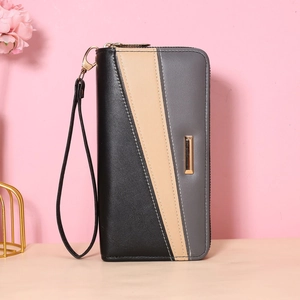 Close-up of tricolor patchwork leather wallet with wristlet and gold metal hardware