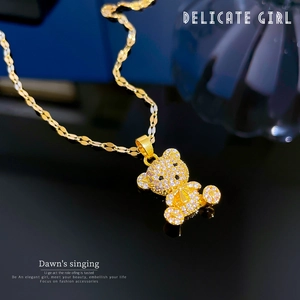 Detailed view of titanium steel bear pendant with micro-pave crystals and gold bow tie
