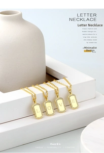 Macro detail of gold-plated rectangular pendant necklace with LOVE letters and zircon inlay