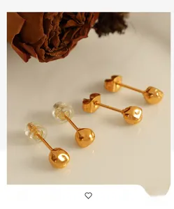 Detailed view of gold ball earrings with hammered texture and two sets of earring backs
