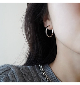 Orecchini a cerchio in argento minimalisti dal design geometrico indossati da modella