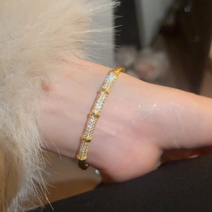 Close-up of gold plated bamboo style bracelet with shimmering pavé zircon stones