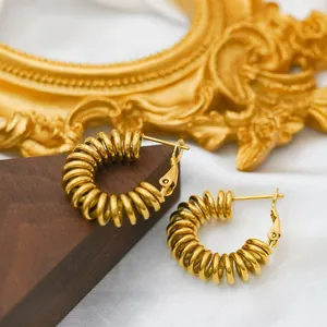 Macro shot of gold-plated chunky spiral spring earrings with lever-back closure detail