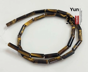 Close-up of polished natural tiger eye cylinder beads with golden brown banding