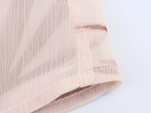 Detail of high-quality double stitching on pink floral chiffon blouse hem or sleeve cuff