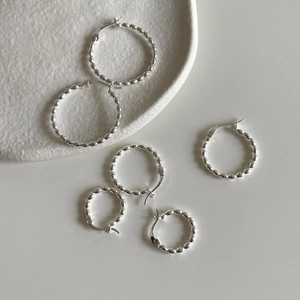 Three sizes of minimalist S925 sterling silver beaded hoop earrings on a white surface