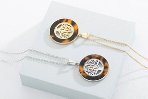 Dettagli di ciondoli albero della vita in oro e argento con inserto in tartaruga