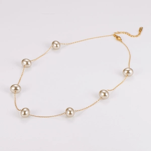 Close-up of golden pearl necklace with eight glowing pearls on a white background