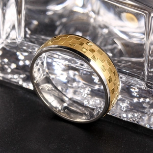 Macro detail of 6mm titanium steel ring featuring gold checkerboard relief and silver edges