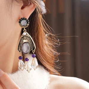 Macro shot of vintage style earrings with grey stones and purple crystal droplets