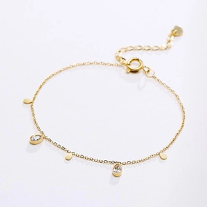 Macro shot of gold-plated chain with teardrop zircons and heart charm detail