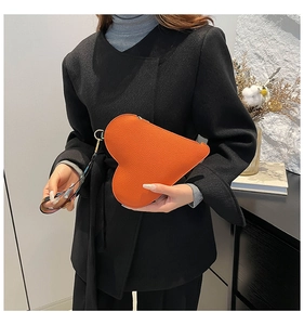 Sac à main orange en forme de cœur avec une large bandoulière aux motifs colorés