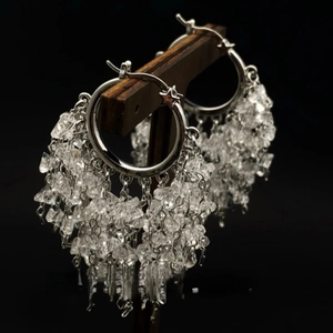Detail of bohemian crystal tassel earrings featuring silver rings and hanging stones