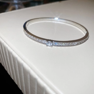 Gros plan détaillé d'un bracelet jonc argenté orné d'une grande pierre ronde en zircon
