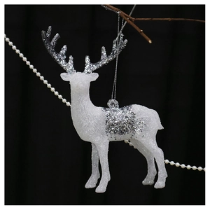 Detail of white reindeer Christmas ornament with silver glitter finish on a dark branch