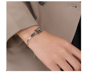 Detailed macro view of a silver belt buckle styled titanium steel bracelet for women