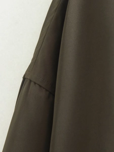 Détail macro de la texture en sergé olive foncé et coutures précises sur veste décontractée
