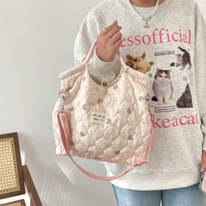 Détail du sac cabas matelassé rose montrant la texture du tissu et la sangle réglable