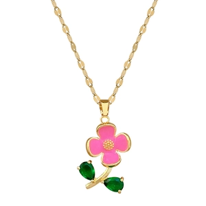 Collier doré avec pendentif fleur rose et feuilles en pierres vertes sur fond blanc