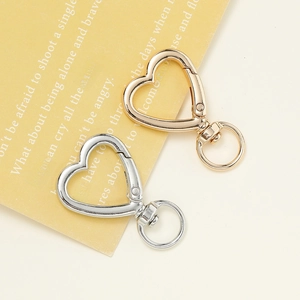 Detail of heart-shaped alloy keychains in gold and silver finishes on a paper card
