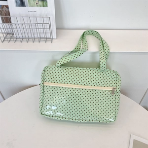Close-up of light green polka dot canvas tote bag with transparent PVC zipper pocket