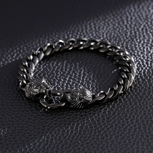 Détail du bracelet cubain à tête de lion en métal foncé sur cuir noir texturé