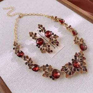 Vintage gold-plated leaf jewelry set with deep red faceted gems and crystals