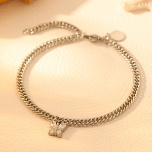 Macro detail of silver butterfly pendant bracelet with cubic zirconia on a cuban chain