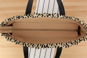 Top view showing the khaki lining, zipper closure, and woven details of the handbag
